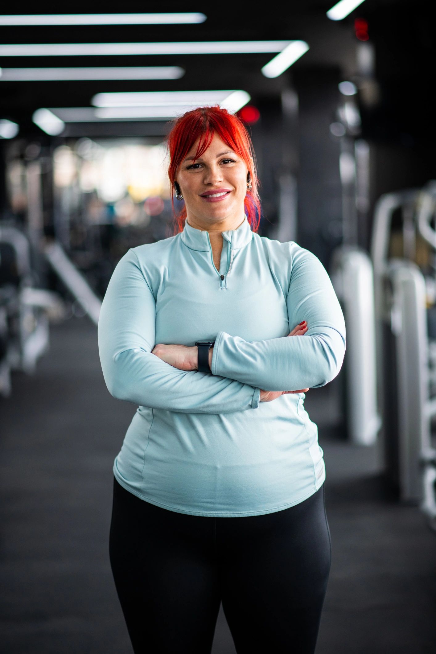 Confident gym member smiling with arms crossed